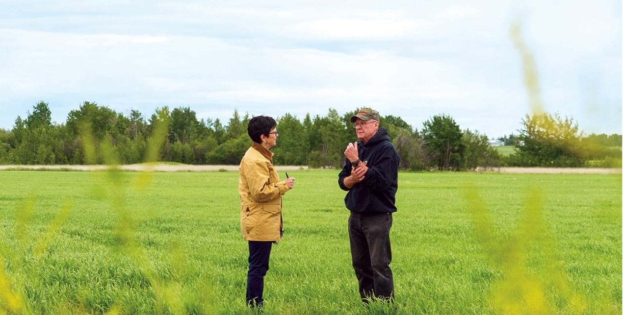 Two people talking in a field